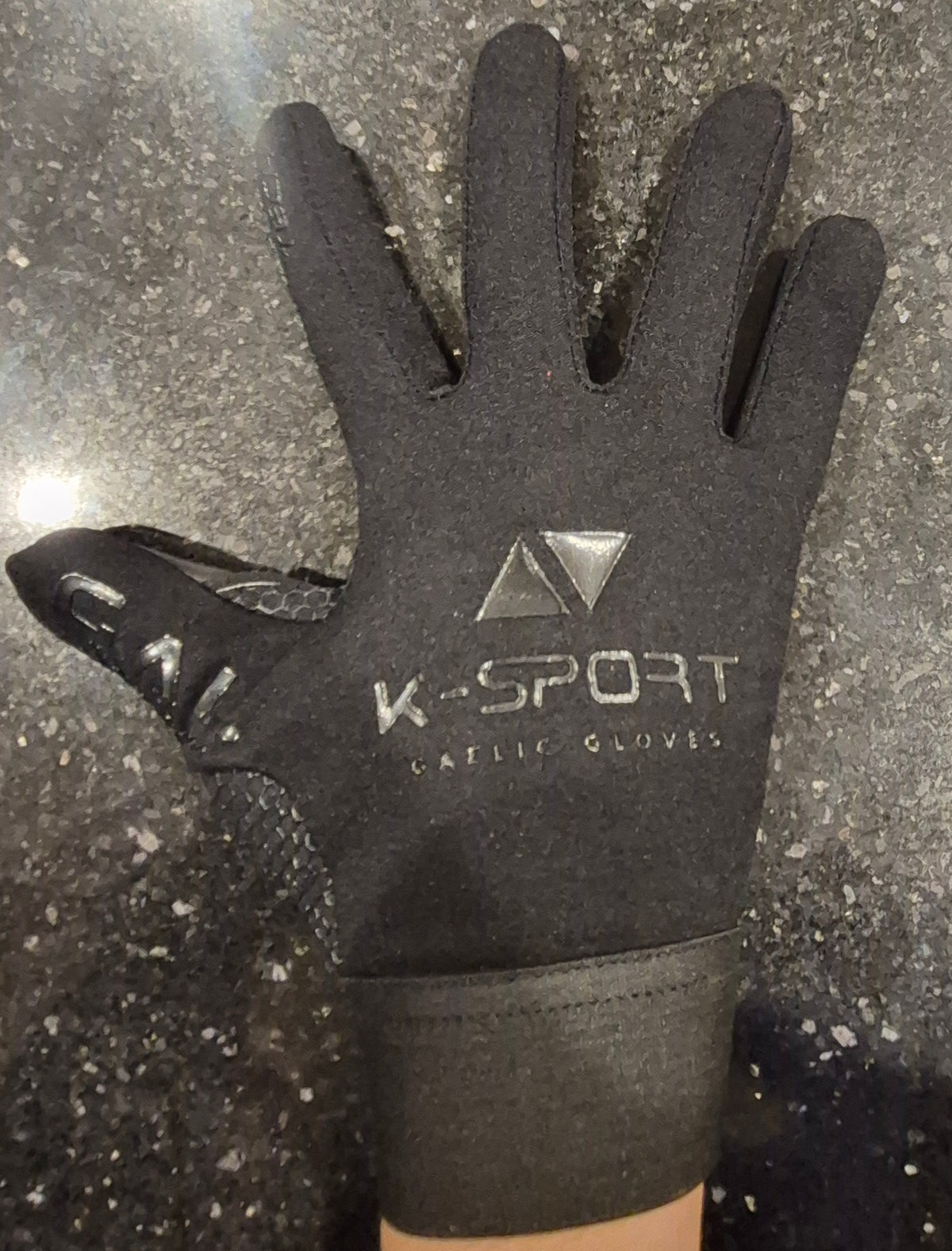 Red gaelic football gloves with a strapless wrist, and gach aon liathróid wrote on inside wrist,  all weather grip